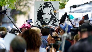 A portrait of Britney Spears looms over supporters and media members outside a court hearing concerning the pop singer's conservatorship in Los Angeles. Pic: AP      